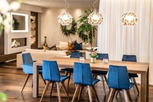 une salle à manger avec une table et des chaises bleues dans l'établissement Luxuriöses Panorama Chalet Penthouse mit Sauna und Hot-Whirpool, à Schenna