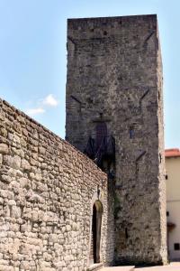 Una pared de ladrillo alta con una torre. en Mittelalterlicher Turm in Pratovecchio mit Panoramaterrasse- ideal für einen romantischen Urlaub, en Stia