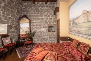 1 dormitorio con cama y pared de ladrillo en Mittelalterlicher Turm in Pratovecchio mit Panoramaterrasse- ideal für einen romantischen Urlaub, en Stia