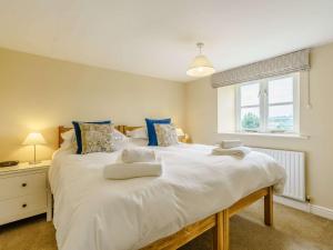 1 dormitorio con 1 cama blanca grande con almohadas azules en 3 Bed in Masham 83728 