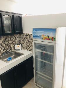 a kitchen with a sink and an empty refrigerator at Apartamento Carmen in Santa Cruz de Barahona