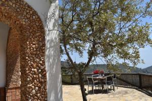 eine Terrasse mit einem Tisch, Stühlen und einem Baum in der Unterkunft Ferienhaus mit Privatpool für 4 Personen ca 120 m in Competa, Andalusien Costa del Sol in Cómpeta