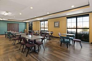 una sala da pranzo con tavoli, sedie e finestre di Comfort Inn & Suites Newcastle - Oklahoma City a Newcastle