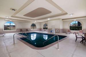 a swimming pool in a large room with tables and chairs at Quality Inn Columbia in Columbia