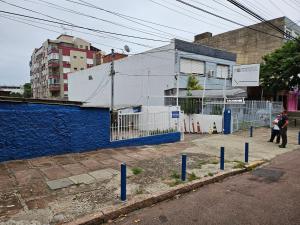a street with blue posts in front of a building at Consulado Americano apartamento 50 metros da entrada para Visto Consulado EUA Porto Alegre com garagem in Porto Alegre