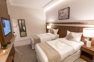Habitación de hotel con 2 camas y TV en Wassad Hotel Makkah فندق وسد مكة en La Meca