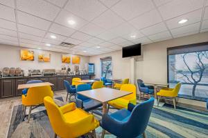 a waiting room with tables and yellow chairs at Comfort Inn Airport Turfway Road in Florence
