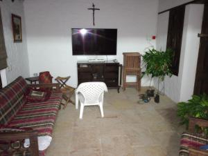 una sala de estar con TV y una cruz en la pared en Villa Helena, en San Gil
