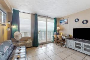 a living room with a couch and a television and a table at Harbour Beach Resort Unit 808 in Daytona Beach