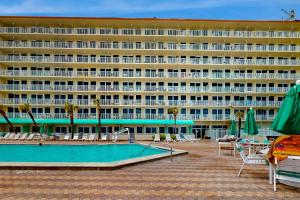 a hotel with a swimming pool in front of a building at Harbour Beach Resort Unit 808 in Daytona Beach