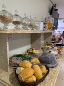 Eine Theke mit einem Haufen Sandwiches und anderen Speisen in der Unterkunft Hotel Flat Almaru - Marília in Marília