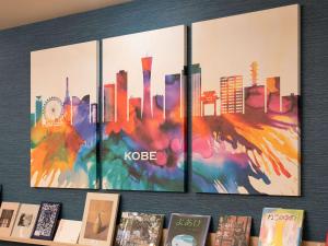 a wall with four paintings of a city at Comfort Hotel ERA Kobe Sannomiya in Kobe