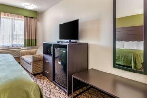 New LondonにあるQuality Innのベッド1台、薄型テレビが備わるホテルルームです。