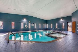 a large swimming pool in a blue room at Quality Inn in New London