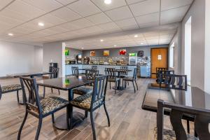 a restaurant with tables and chairs and a counter at Quality Inn in New London