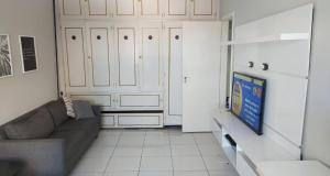 a living room with a couch and a closet at Pé na Areia em Santos in Santos