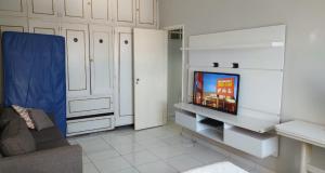 a living room with a tv and a couch at Pé na Areia em Santos in Santos