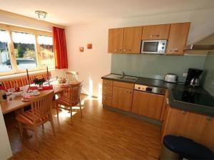 uma cozinha com uma mesa e uma sala de jantar em Komfortable Ferienwohnung mit zwei Doppelzimmern und zwei Badezimmern em Schröcken