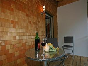 uma mesa com uma garrafa de vinho e um copo em Komfortable Ferienwohnung mit zwei Doppelzimmern und zwei Badezimmern em Schröcken