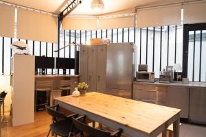 a kitchen with a wooden table and a refrigerator at Lovely loft in the heart of Paris in Paris