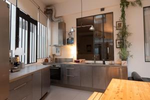 a large kitchen with stainless steel appliances and windows at Lovely loft in the heart of Paris in Paris