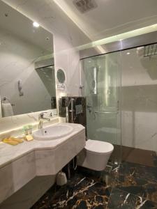 a bathroom with a sink and a toilet and a shower at Wassad Hotel Makkah فندق وسد مكة in Makkah