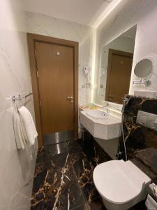 La salle de bains est pourvue de toilettes, d'un lavabo et d'un miroir. dans l'établissement Wassad Hotel Makkah فندق وسد مكة, à La Mecque