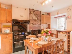 a kitchen with a wooden table with chairs and a stove at 2 Bed in Wasdale SZ580 in Santon Bridge