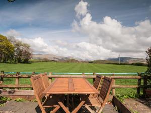 a wooden table and two chairs in front of a field at 2 Bed in Wasdale SZ580 in Santon Bridge