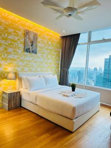 um quarto com uma cama grande e uma parede amarela em Vortex Suites KLCC By MA Tajri em Kuala Lumpur