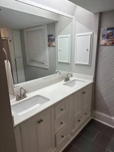 a bathroom with two sinks and a large mirror at Luxury Stay in Montrose- Parma _ the Italian Plaza in Houston