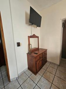 tocador con espejo y TV en la pared en MAZATLÁN, Casa Completa 2 Pisos Residencial Rinconada, en Mazatlán