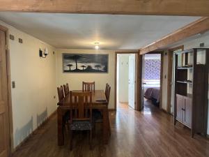 a dining room with a table and chairs and a bedroom at Casa Ann in Osorno