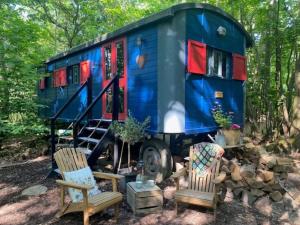 a blue and red train car sitting in the woods at 1 Bed in Pett 81329 in Pett