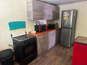una cucina con piano cottura e frigorifero di Casa Ann a Osorno