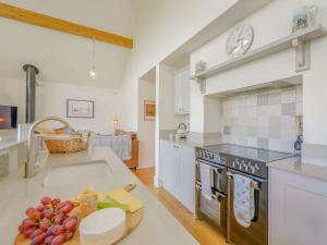 una cucina con lavandino e orologio sul muro di 2 Bed in Montgomery 83244 a Llandyssil