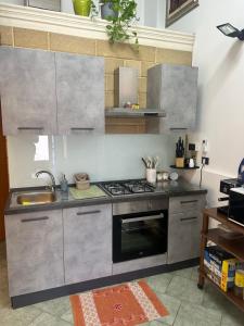 a kitchen with a stove and a sink at Camine Home in Aradeo