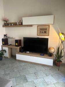 a living room with a flat screen tv on a wall at Camine Home in Aradeo