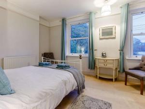 a bedroom with a bed and a chair and a window at 4 Bed in Bideford 85720 in Bideford