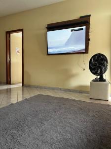 Zimmer mit einem Flachbild-TV und einem Ventilator. in der Unterkunft Casa de Campo Domingos Martins in Domingos Martins