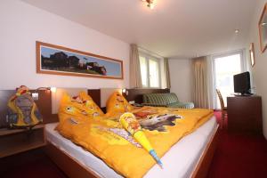 a bedroom with a large bed with a yellow comforter with a toyasy at Wohnung in Kappl mit Eigenem Balkon in Kappl