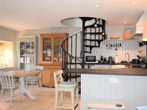 a kitchen and dining room with a spiral staircase at 1 bed in Exbridge 85219 in Skilgate