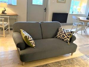 a gray couch with pillows on it in a living room at 1 bed in Exbridge 85219 in Skilgate