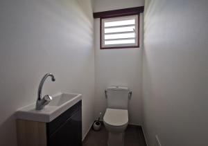 a bathroom with a toilet and a sink and a window at Villa - 3 chambres climatisées - proche plages Nord Grande-Terre in Anse-Bertrand