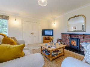 a living room with a couch and a fireplace at 3 Bed in Llanrhaeadr Ym Mochnant 85799 in Llanrhaeadr-ym-Mochnant