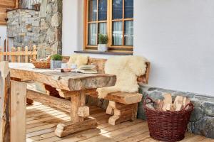 einen Holztisch und eine Bank auf einer Terrasse in der Unterkunft Komfortables Ferienhaus in Flachau mit Terrasse, Garten und Sauna und Panoramablick in Flachau