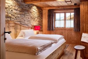 two beds in a room with a stone wall at Komfortables Ferienhaus in Flachau mit Terrasse, Garten und Sauna und Panoramablick in Flachau