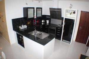 uma cozinha com um balcão preto e um lavatório em Ferienhaus mit hellem Wohnbereich, zwei Schlafzimmern und einer Terrasse em Guía de Isora