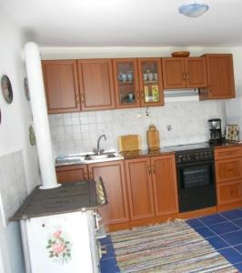 a kitchen with wooden cabinets and a stove at Freistehendes Ferienhaus in Döbrököz mit Garten, Terrasse und Grill in Döbrököz