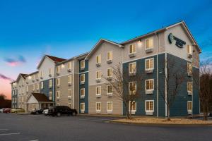 ein großes Apartmenthaus auf einem Parkplatz in der Unterkunft WoodSpring Suites Macon West I-475 in Macon